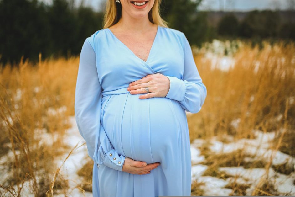 smiling pregnant woman in a sky blue dress