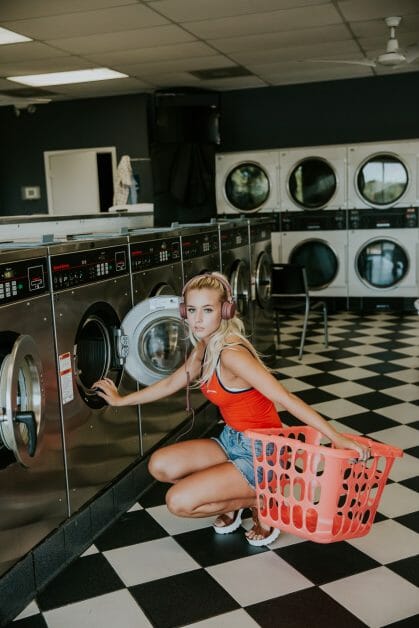 woman kneeling with laundry basket on her side at the laundry shop