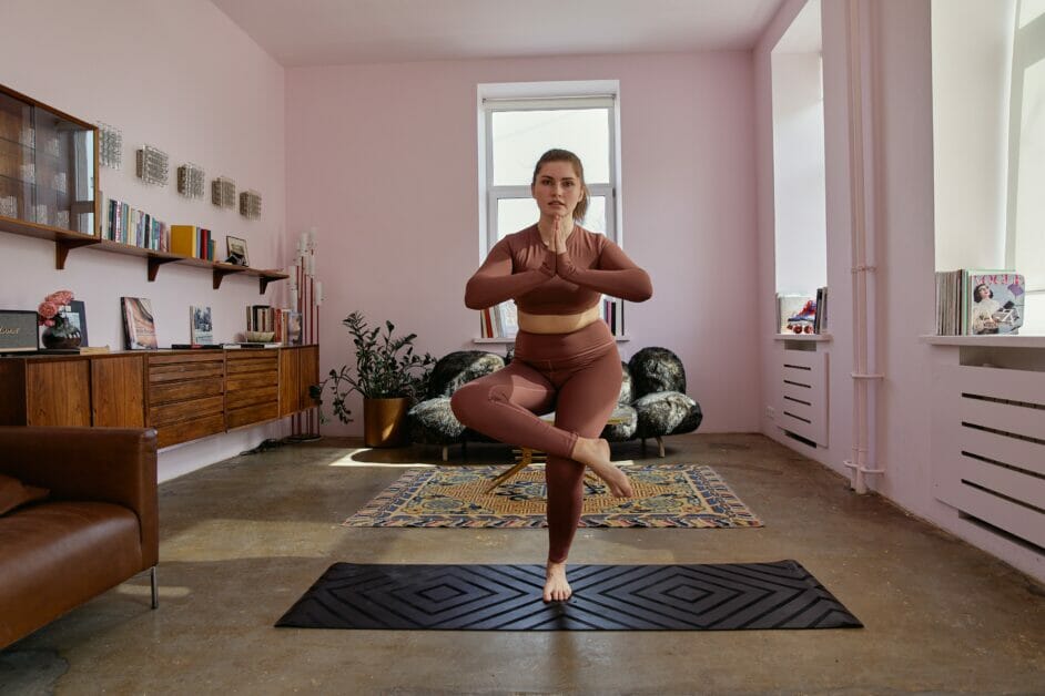 a woman doing yoga's namaste pose with one leg