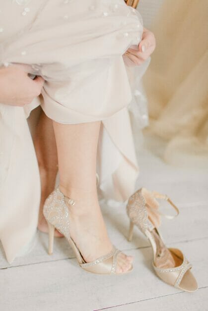 bride putting on her wedding shoes
