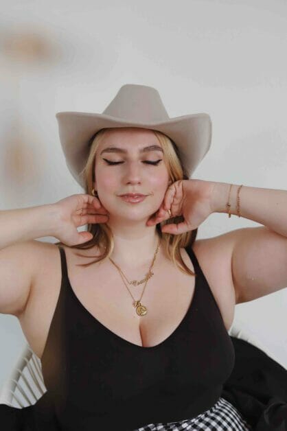 plus-size woman in a black sleeve and hat