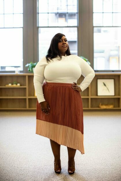 plus size woman in a white long sleeve match with a-line symmetrical cut skirt