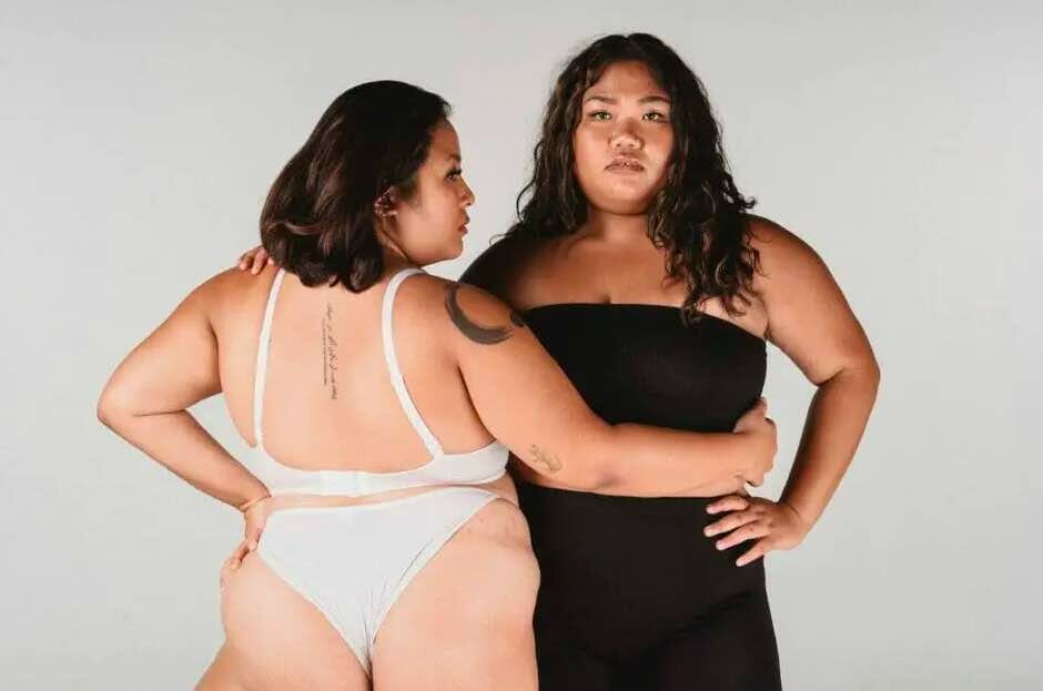 two plus-size in shapewears posing back to back