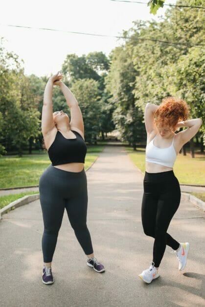 two woman dancing outdoor after a successful workout