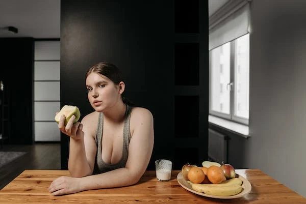 woman sitting on the table eating fruit