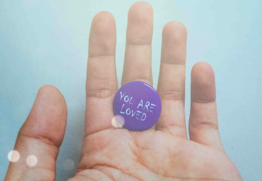 you are loved button messge at the palm of a hand