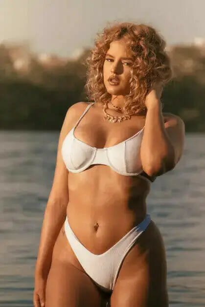 woman with curly hair in a white two-piece bikini