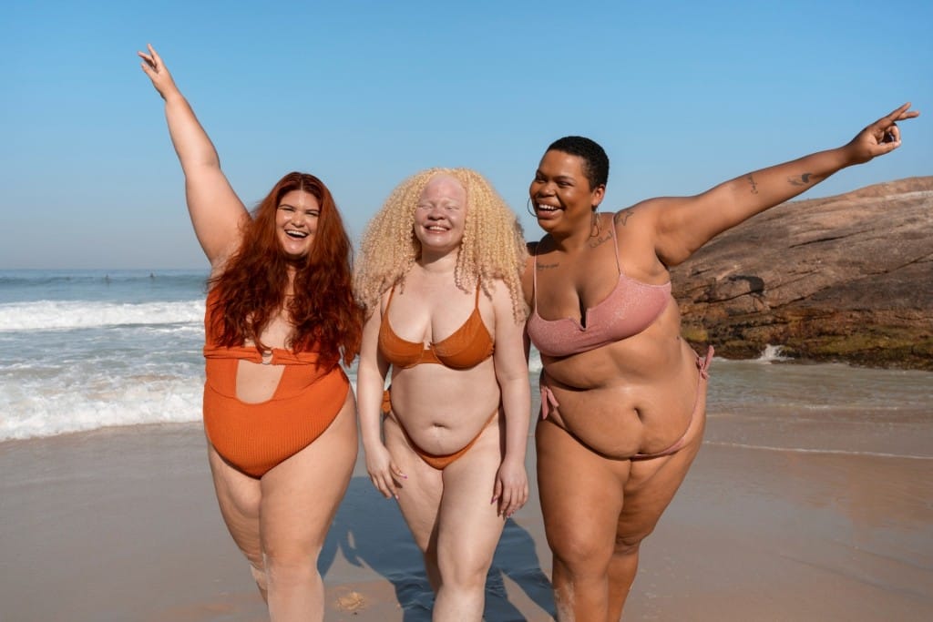 full shot plus size women posing seaside